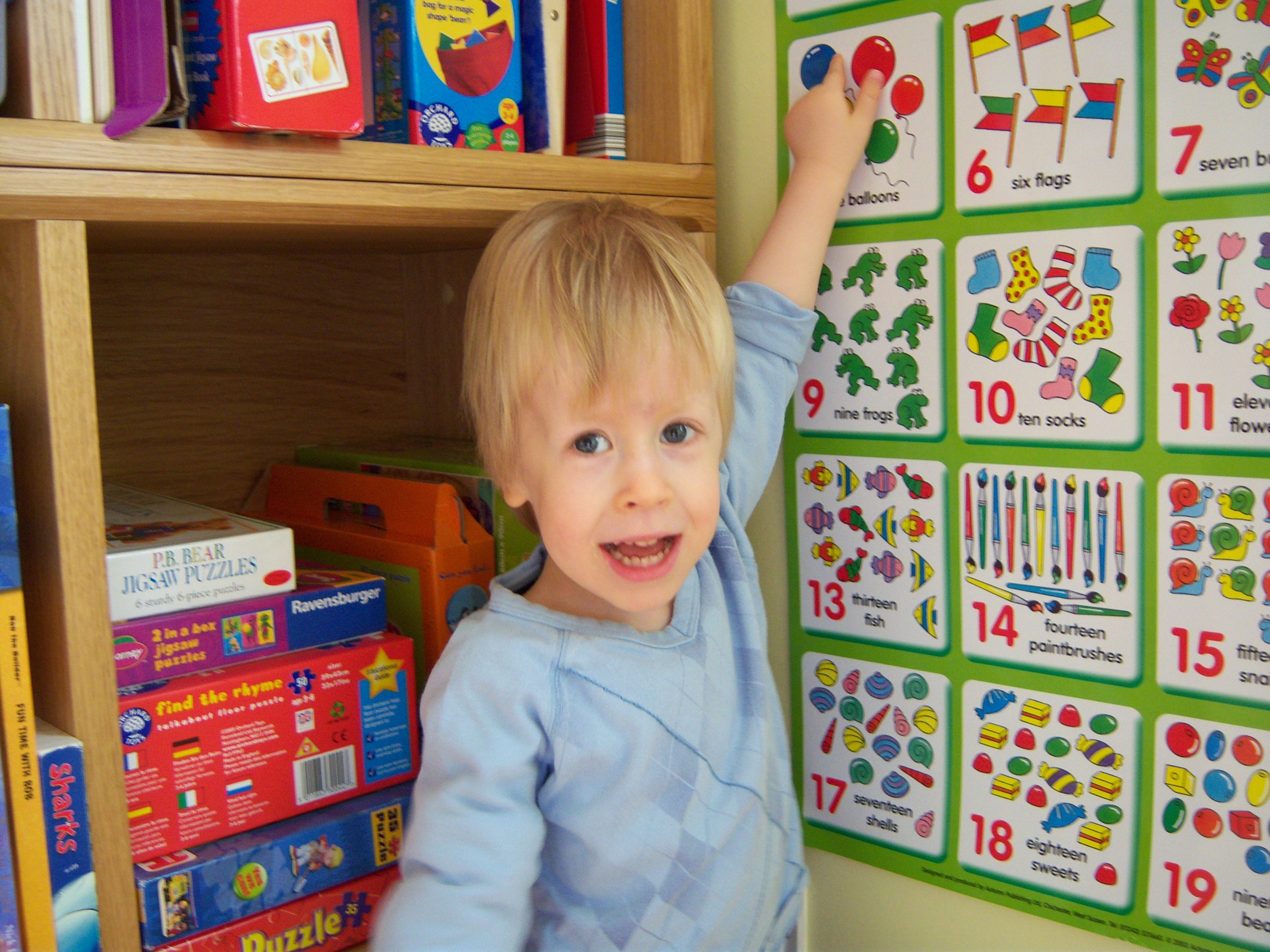 young child pointing at maths number wall