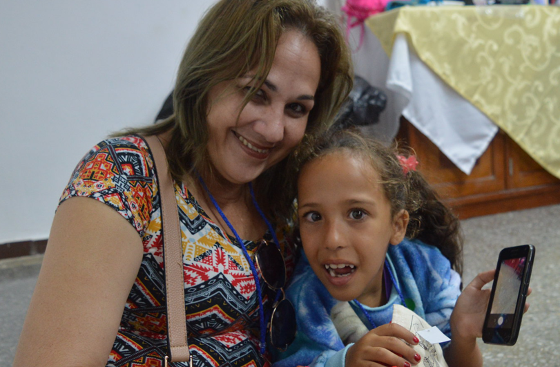 New-parents Woman in colourful top with child holding a mobile phone