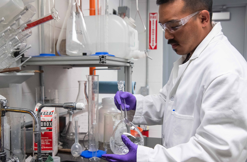 scientist in white lab coat using equipment