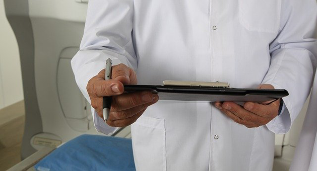 doctor-1228627_640 doctor in white coat holding a electronic device