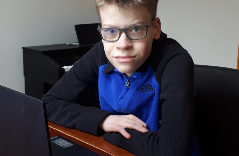 education-and-transition boy in a blue and black top sat at a laptop