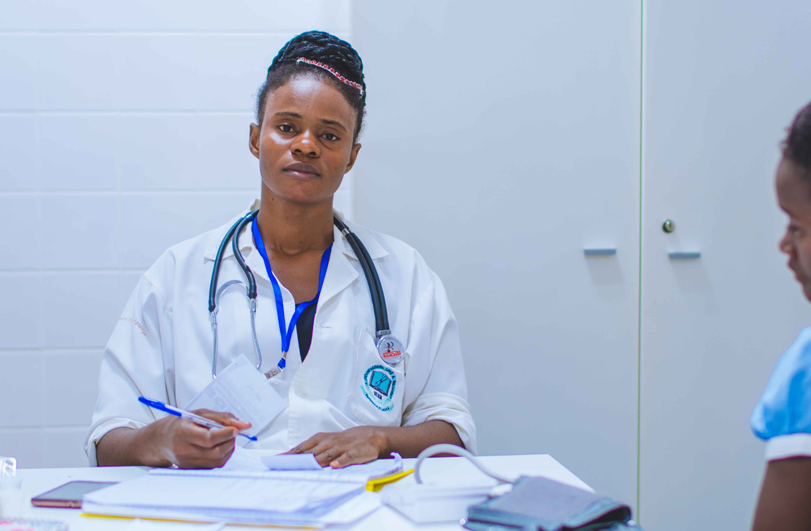 doctor in lab coat and stethascope with a young patient